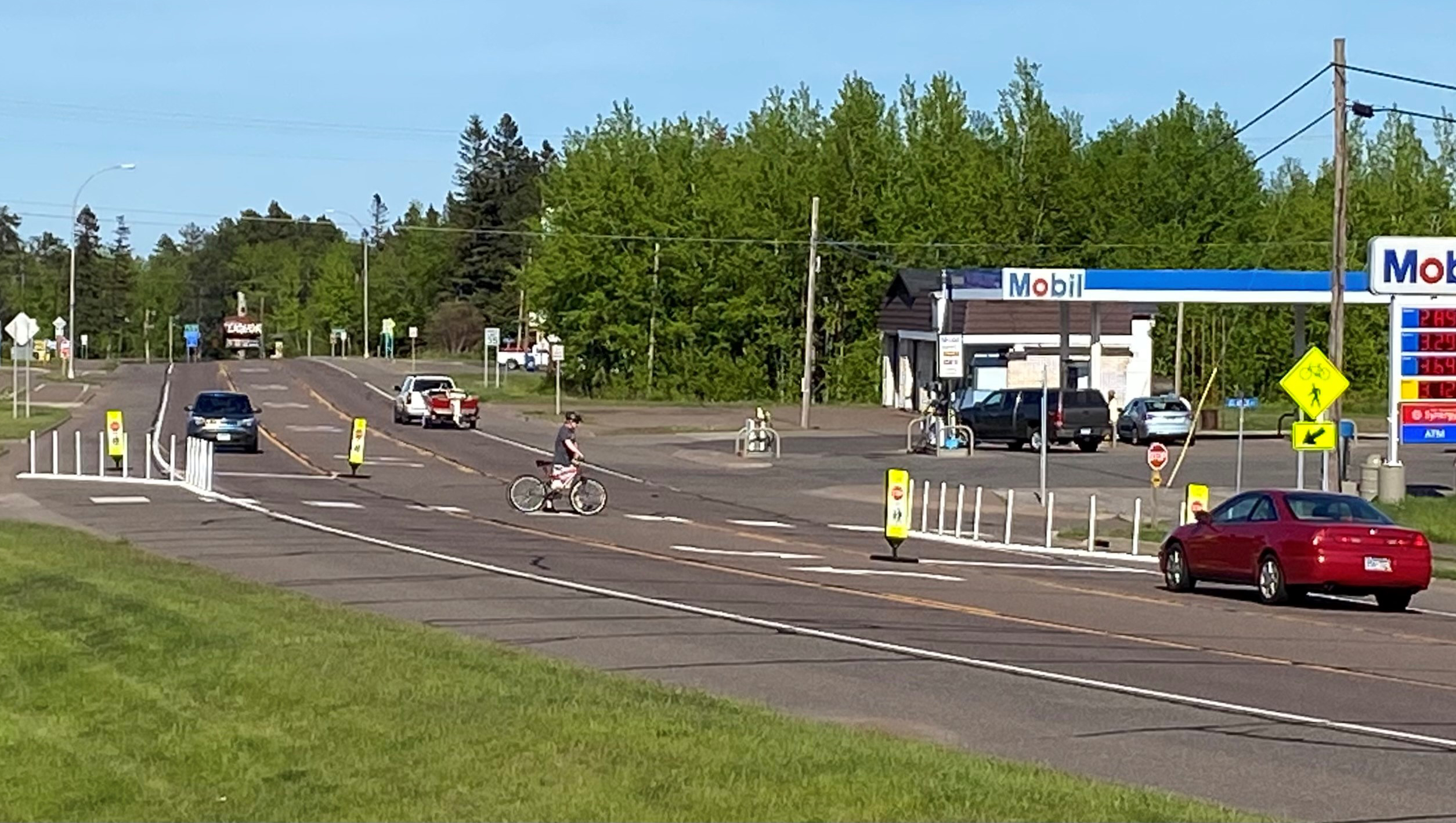 Photo: a pedestrial crossing the road. New MnDOT signage to alert drivers is clearly visible.